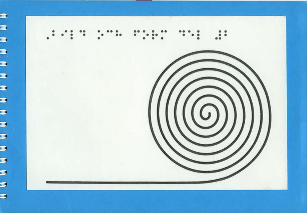 Spiralbunden bok med blått och grått omslag med en svart spiral på. Punktskrift i överkanten.